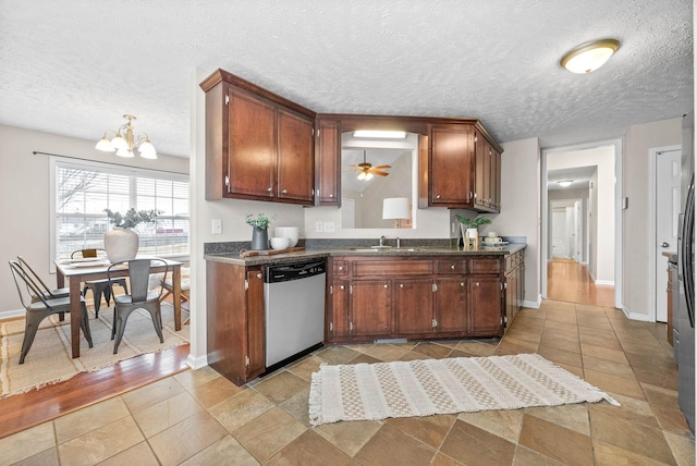 kitchen with ceiling fan with notable chandelier, sink, stainless steel dishwasher, and a textured ceiling