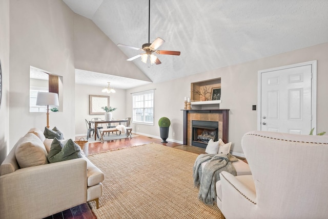 living room featuring high vaulted ceiling, a textured ceiling, hardwood / wood-style flooring, ceiling fan, and a fireplace