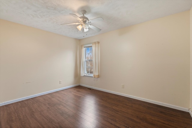 empty room with ceiling fan, dark hardwood / wood-style floors, and a textured ceiling