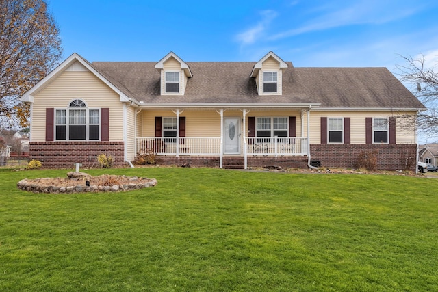 new england style home featuring a front yard and covered porch