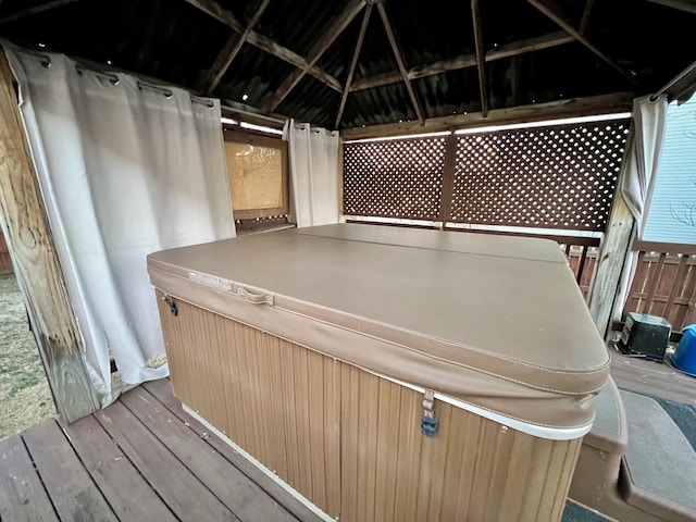 wooden terrace featuring a hot tub and a gazebo