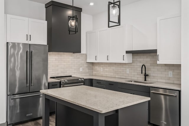 kitchen featuring a center island, sink, hanging light fixtures, white cabinetry, and stainless steel appliances