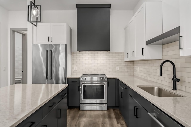 kitchen featuring pendant lighting, sink, appliances with stainless steel finishes, light stone counters, and white cabinetry