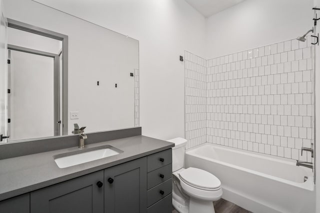 full bathroom with vanity, toilet, wood-type flooring, and tiled shower / bath combo