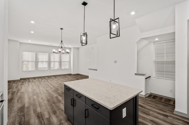 kitchen with a chandelier, dark hardwood / wood-style flooring, a kitchen island, and pendant lighting