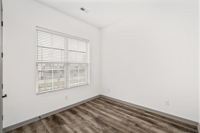 empty room with dark hardwood / wood-style flooring