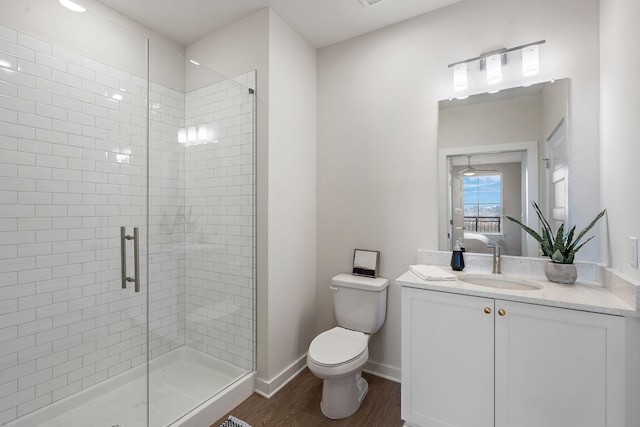 bathroom featuring vanity, hardwood / wood-style flooring, toilet, and a shower with door