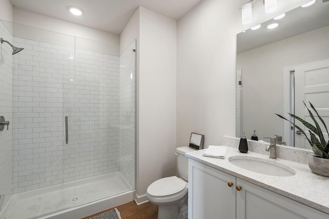 bathroom featuring hardwood / wood-style flooring, vanity, toilet, and a shower with door