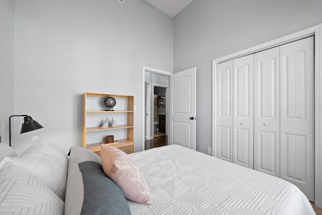 bedroom featuring hardwood / wood-style flooring, high vaulted ceiling, and a closet