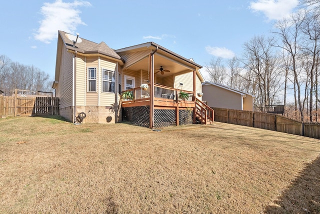 rear view of property featuring a deck, ceiling fan, and a lawn