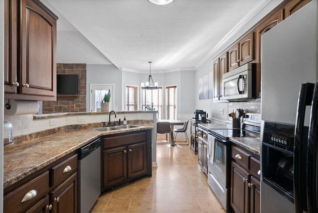 kitchen with hanging light fixtures, sink, appliances with stainless steel finishes, tasteful backsplash, and a chandelier