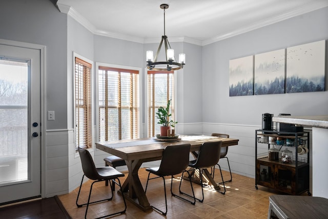 dining space featuring ornamental molding, tile walls, a healthy amount of sunlight, and a notable chandelier