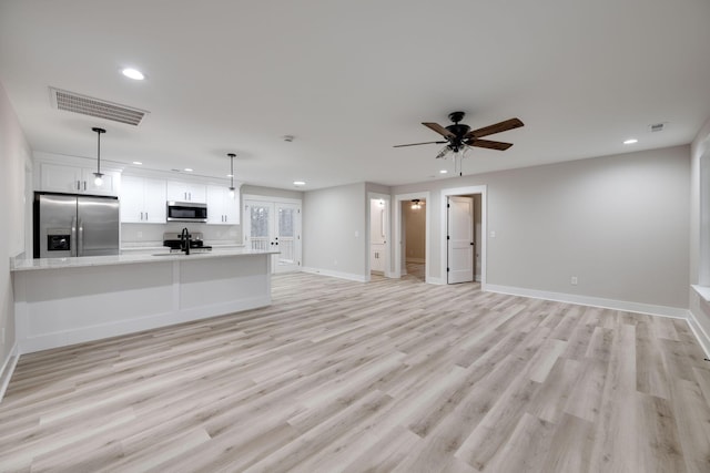 unfurnished living room with ceiling fan, light hardwood / wood-style floors, and sink