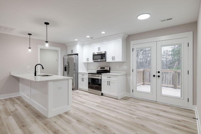 kitchen with white cabinets, french doors, stainless steel appliances, and decorative light fixtures