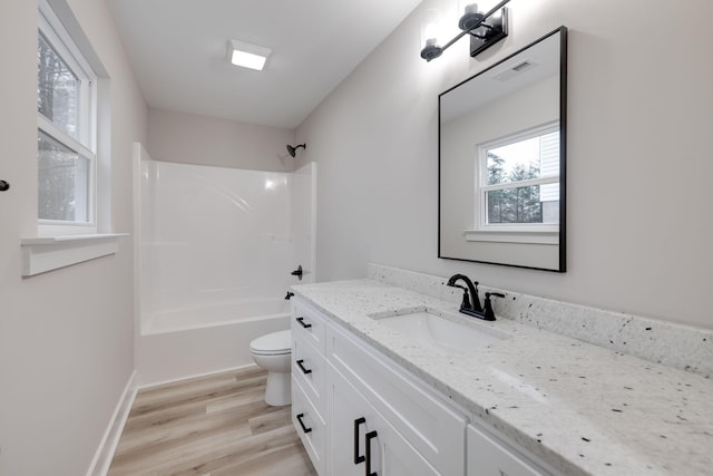 full bathroom featuring washtub / shower combination, wood-type flooring, vanity, and toilet