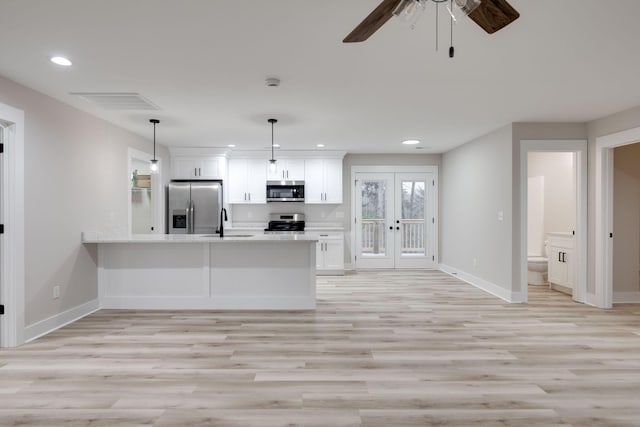 kitchen with french doors, stainless steel appliances, sink, pendant lighting, and white cabinetry