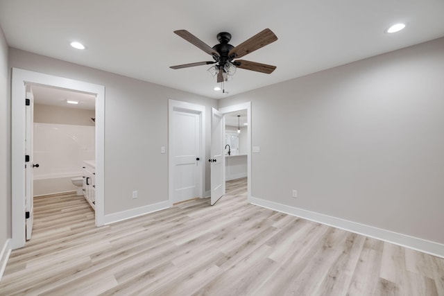 unfurnished bedroom with light wood-type flooring, a closet, ensuite bath, and ceiling fan