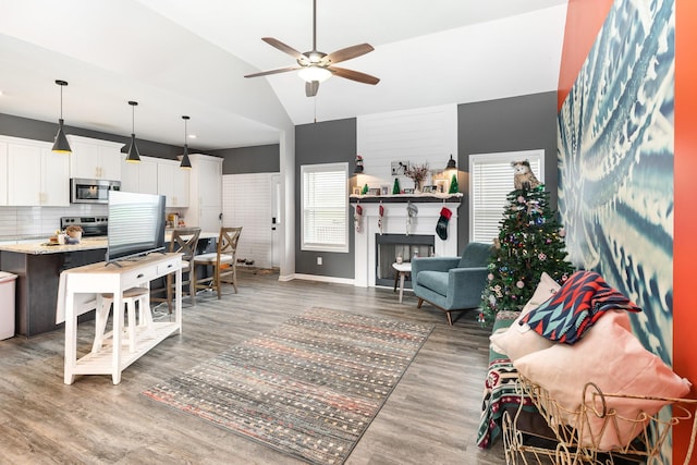 living room featuring hardwood / wood-style flooring, ceiling fan, and high vaulted ceiling