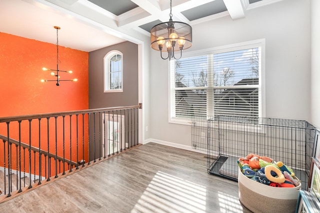 interior space with beam ceiling, hardwood / wood-style floors, coffered ceiling, and an inviting chandelier