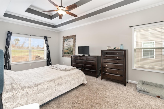 carpeted bedroom featuring ceiling fan, a raised ceiling, and crown molding