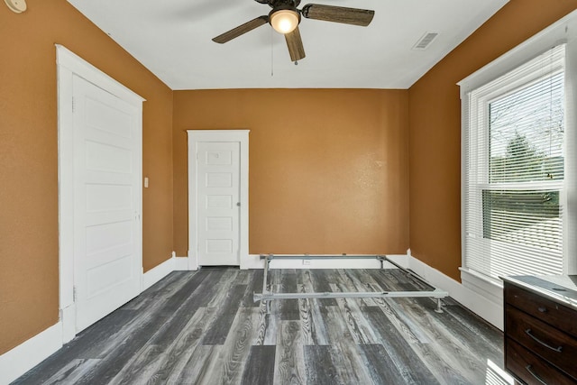 unfurnished room with dark hardwood / wood-style flooring and ceiling fan