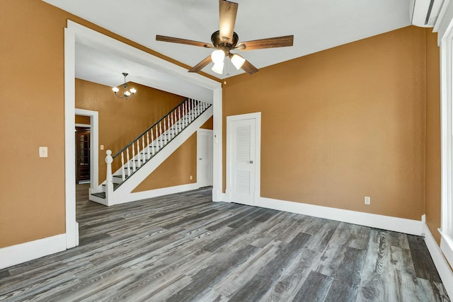 unfurnished living room featuring ceiling fan with notable chandelier, dark wood-type flooring, and a wall mounted AC