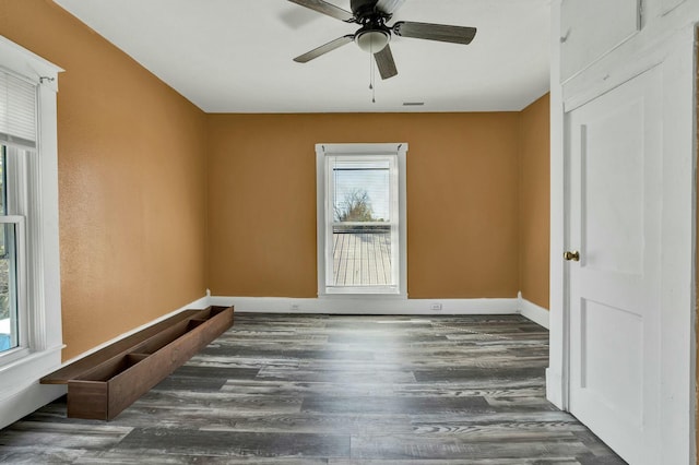 unfurnished room featuring ceiling fan and dark wood-type flooring