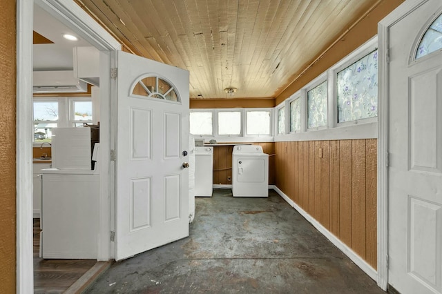 laundry room with wood walls, washing machine and dryer, wooden ceiling, and sink