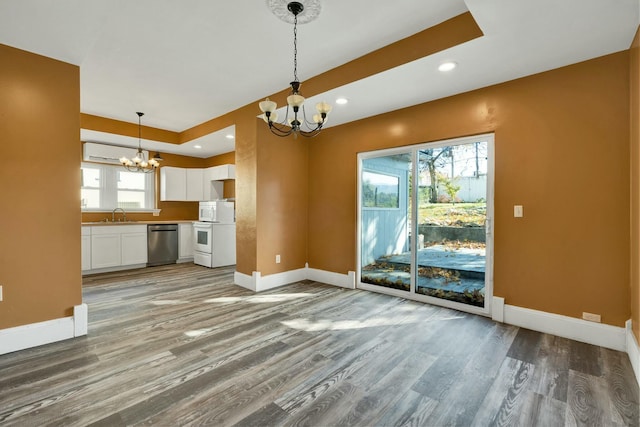 kitchen with decorative light fixtures, white cabinetry, white appliances, and a wealth of natural light