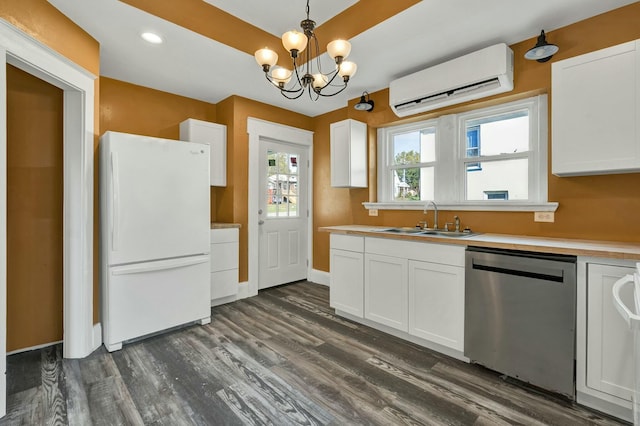 kitchen with sink, stainless steel dishwasher, white refrigerator, an AC wall unit, and white cabinets