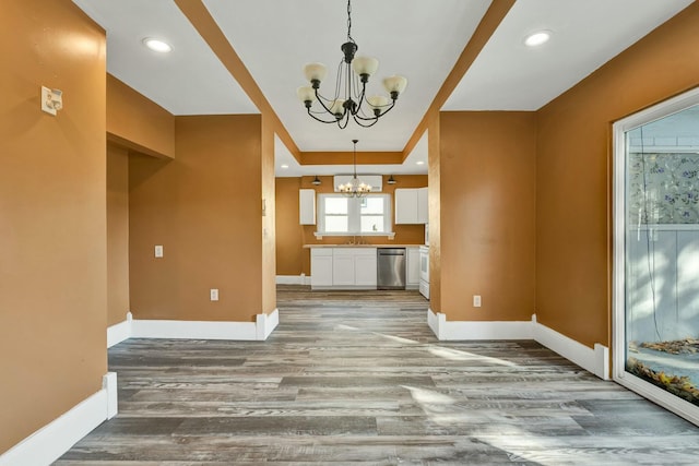 unfurnished living room featuring hardwood / wood-style floors, a chandelier, and sink