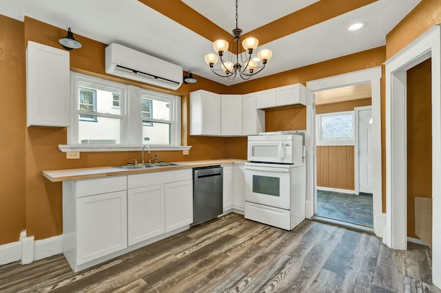 kitchen featuring white appliances, an AC wall unit, sink, and a wealth of natural light