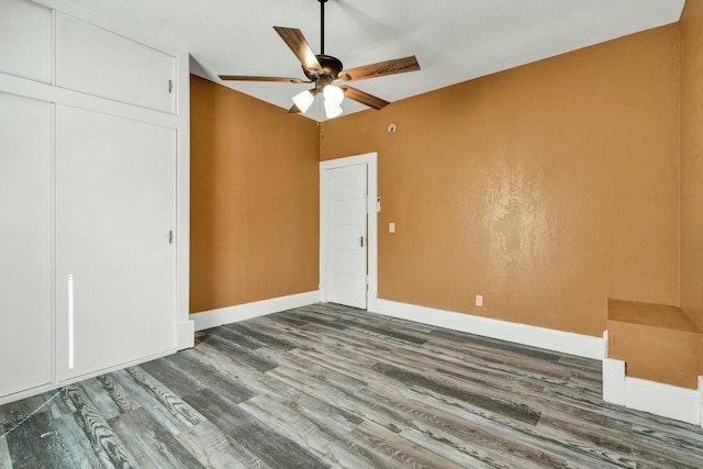 unfurnished bedroom featuring ceiling fan, a closet, and wood-type flooring