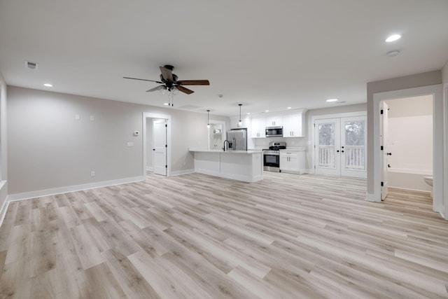 unfurnished living room with ceiling fan, french doors, and light wood-type flooring