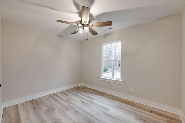 empty room with ceiling fan and light hardwood / wood-style flooring