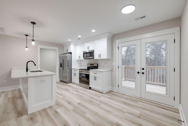 kitchen with white cabinets, decorative light fixtures, stainless steel appliances, and french doors