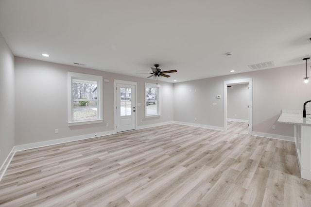 unfurnished living room with ceiling fan and light hardwood / wood-style floors