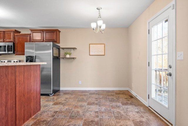 kitchen featuring stainless steel appliances, hanging light fixtures, and a notable chandelier