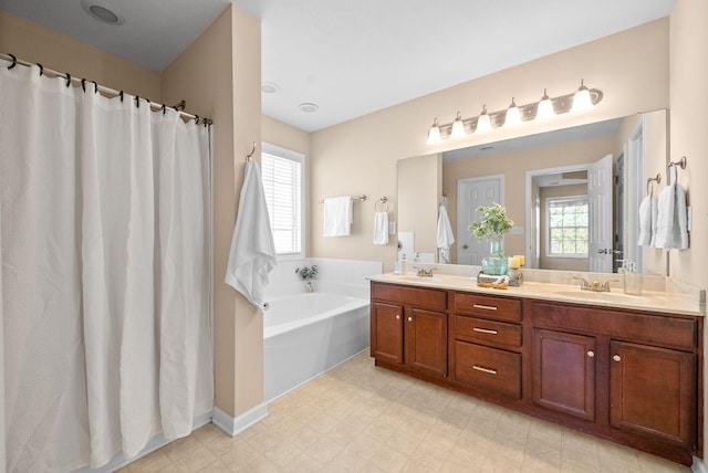 bathroom with a bathing tub, plenty of natural light, and vanity