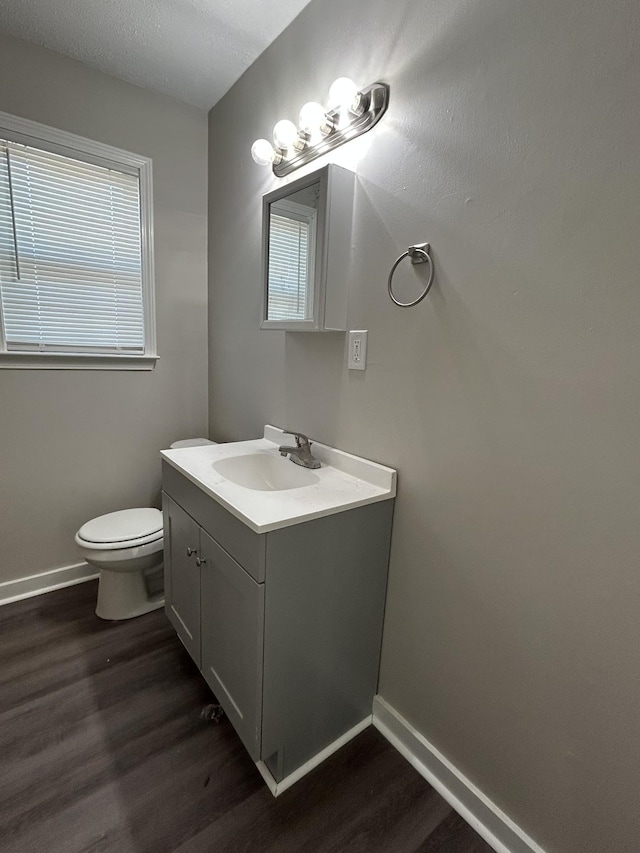 bathroom featuring hardwood / wood-style floors, vanity, plenty of natural light, and toilet