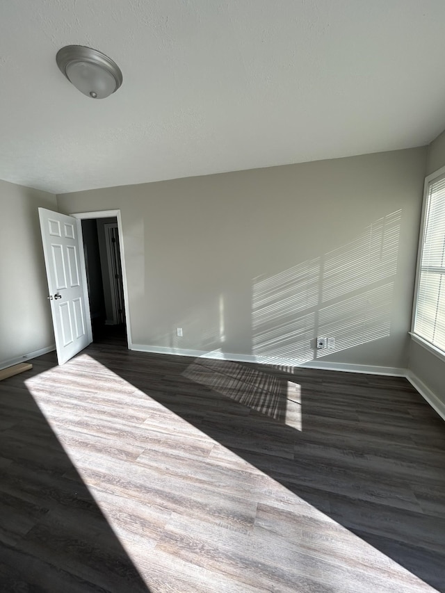 spare room featuring dark wood-type flooring