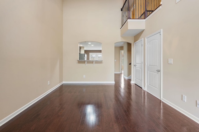 interior space featuring dark hardwood / wood-style flooring and a towering ceiling