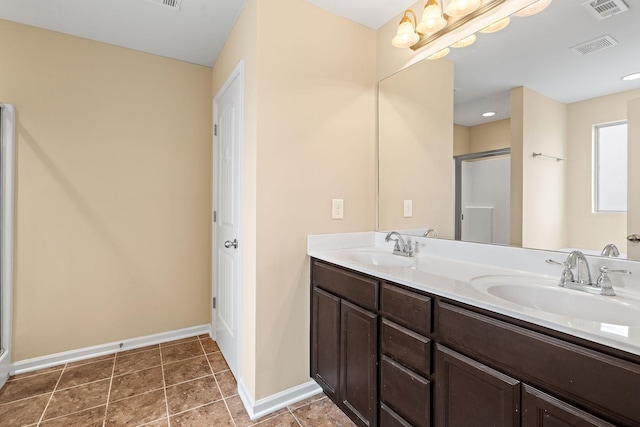 bathroom with tile patterned floors, vanity, and an enclosed shower