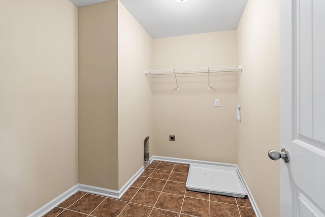 laundry area featuring hookup for an electric dryer, hookup for a washing machine, and dark tile patterned flooring