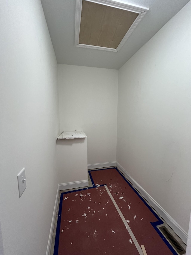 spare room with attic access, visible vents, and baseboards