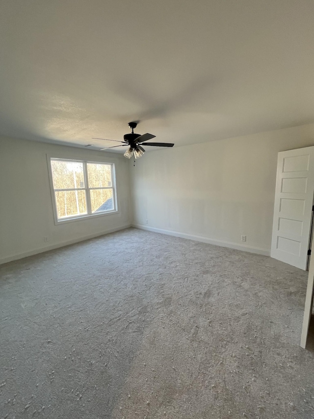 empty room with a ceiling fan and baseboards