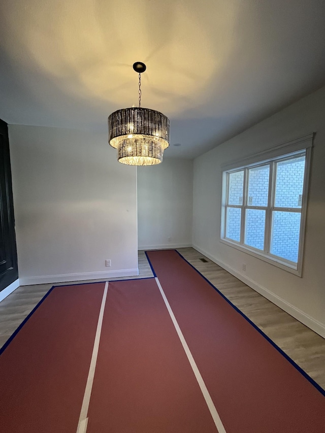 unfurnished dining area with baseboards and wood finished floors