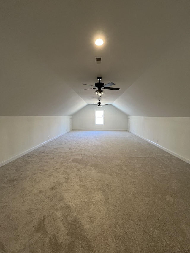 additional living space with vaulted ceiling, carpet floors, a ceiling fan, and baseboards