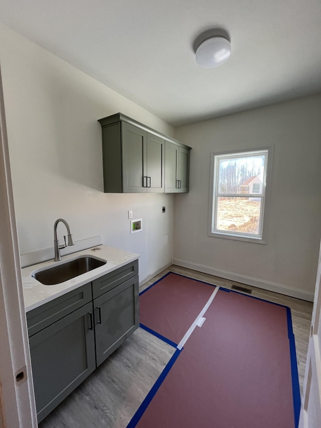 washroom featuring washer hookup, wood finished floors, visible vents, a sink, and electric dryer hookup