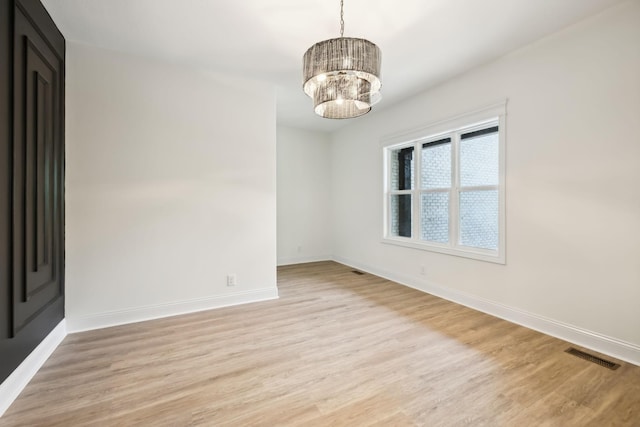 1049 Gholson Rd, Clarksville, TN 37043 - empty room featuring light wood finished floors, baseboards, visible vents, and a chandelier